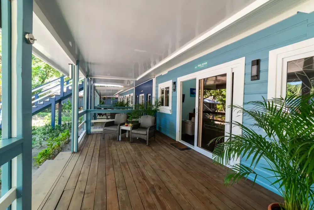 Shared wooden veranda with lounge chairs outside the studios