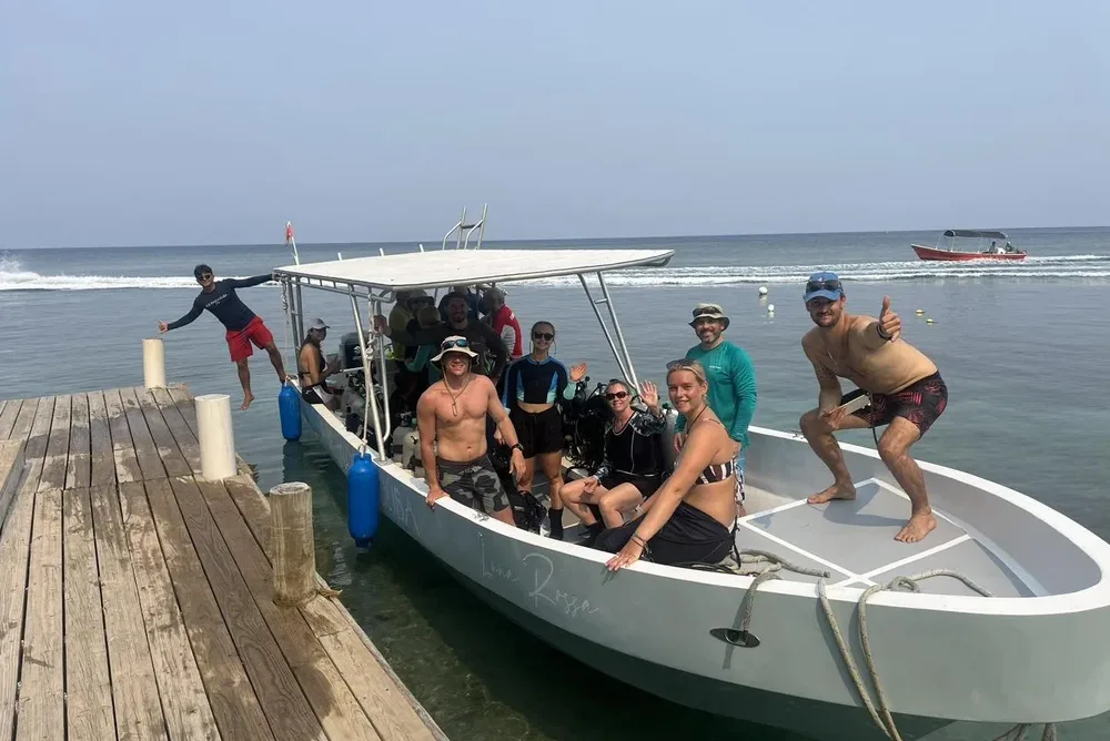 Blue Moon Scuba&rsquo;s dive boat tied up at the dock, crew and divers aboard and smiling